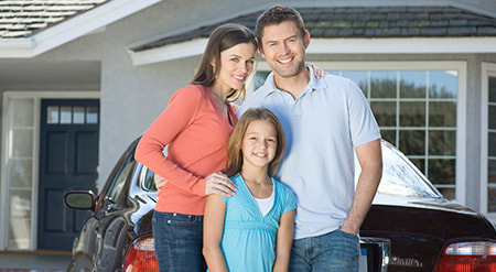 Happy caucasian family standing behind the car outside of their house photohouse 